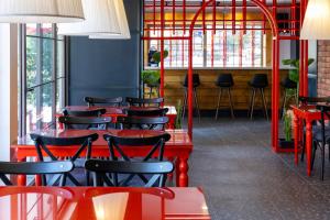 a row of red tables and chairs in a restaurant at 7inn in Antalya