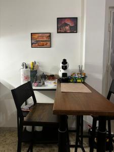 eine Küche mit einem Holztisch, Stühlen und einer Theke in der Unterkunft Cavour Housing in Bari