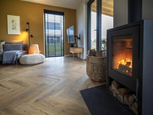 a living room with a fireplace and a couch at Beautiful villa on the water in Friesland in Sint Nicolaasga +32 photos