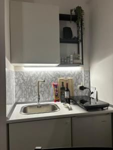 eine Küchentheke mit einem Waschbecken und einem Spiegel in der Unterkunft Cavour Housing in Bari