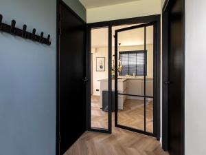 a black door with a mirror in a room at Beautiful villa on the water in Friesland in Sint Nicolaasga