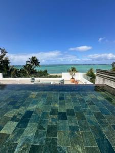 an infinity pool with the ocean in the background at Superbe penthouse sur la plage in Riambel