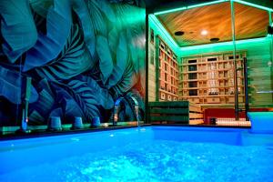 a bathroom with a large tub in a room with a mural at Dimora il Tartufo Relax e Benessere con Spa Privata in Busso