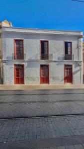 un edificio blanco con puertas y ventanas rojas en Hotelito Boutique Tenerife Guimerá, en Santa Cruz de Tenerife