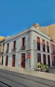 un edificio blanco con puertas rojas en una calle en Hotelito Boutique Tenerife Guimerá, en Santa Cruz de Tenerife