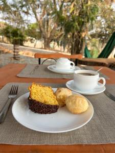a plate with a piece of cake and a cup of coffee at Pousada e Flat Royal 04 in Itapecerica +20 photos