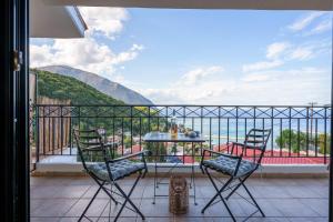 a balcony with a table and chairs and a view at Giannatos' Studios - Makis in Póros Kefalonias