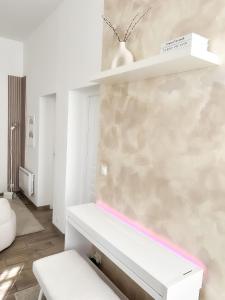een witte kamer met een witte bank en een muur bij Le Petit Cocon - Pause douceur in Cambrai