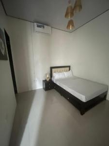 a bedroom with a bed in a white room at Us Ville Inn in Valencia +4 photos