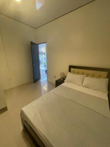 a bedroom with a large white bed and a doorway at Us Ville Inn in Valencia