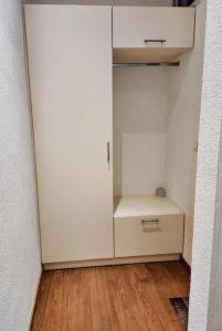 a white cabinet in a room with a wooden floor at Traumwohnung direkt am Thunersee in Oberhofen am Thunersee