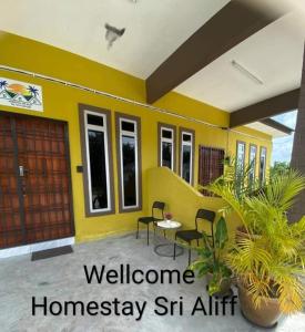 a yellow house with a yellow wall at Homestay Sri Aliff in Sri Gading