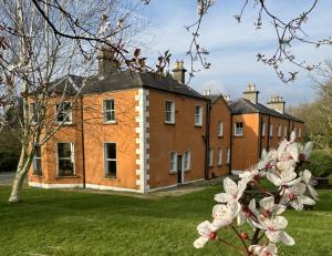 a large brick building in the middle of a yard at Clone Country House in Aughrim