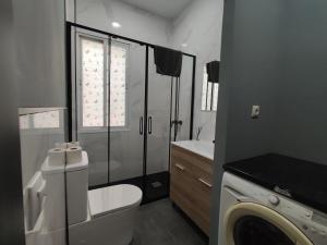 łazienka z toaletą i pralką w obiekcie Apartment la paz w Madrycie