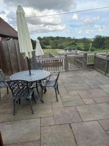 a table and chairs with an umbrella on a patio at 3 Coopers Cottages, Bodiam, East Sussex in Bodiam