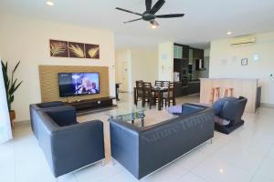 a living room with a flat screen tv and blue chairs at Nature Home 2 - Swiss Garden Resort Residences Beachfront Villa - Weekend Free Breakfast in Kuantan