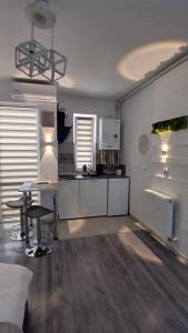 a kitchen with white cabinets and a table and chairs at Sfanta Agnes self check in in Popeşti-Leordeni +5 photos