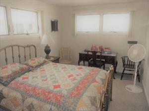 a bedroom with a bed and a desk and windows at Sea Breeze - W007 Brought to you by GetAway Vacations in Wells +10 photos