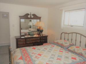 ein Schlafzimmer mit einem Bett mit einer Kommode und einem Spiegel in der Unterkunft Sea Breeze - W007 Brought to you by GetAway Vacations in Wells + 9 Fotos