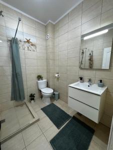 a bathroom with a white sink and a toilet at Apartament MaGiFa Mamaia Nord in Năvodari