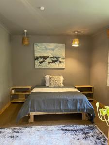 a bedroom with a bed and a painting on the wall at Tulia Room in Dar es Salaam