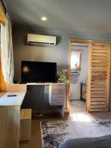 a living room with a flat screen tv and a room with a door at Tulia Room in Dar es Salaam