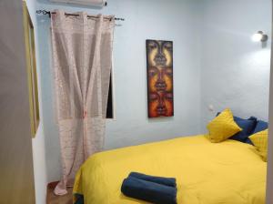 sypialnia z żółtym łóżkiem i 2 zdjęciami na ścianie w obiekcie Apartment la paz w Madrycie