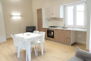a kitchen and dining room with a white table and chairs at Moon Valley Holiday Home in Lauria Inferiore