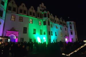 a group of people standing in front of a building with green lights at Wohnung Schlossblick in Celle +5 photos