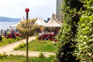 Eine Gruppe von Zelten mit Tischen und Stühlen neben dem Wasser in der Unterkunft Hotel New Riviera bukavu in Bukavu
