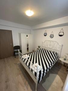 a bedroom with a bed with a black and white striped comforter at Roxi's Apartment in Sibiu