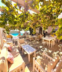 a patio with tables and chairs and a pool at Aphrodite Boutique Hotel in Aliki