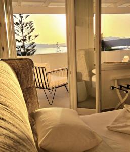 a bedroom with a couch and a view of a balcony at Aphrodite Boutique Hotel in Aliki