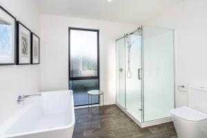 a bathroom with a glass shower and a toilet at Luxe on Burgundy in Martinborough 