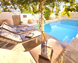 a swimming pool with a table and chairs next to it at Aphrodite Boutique Hotel in Aliki