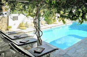 a swimming pool with two chairs and a table next to it at Aphrodite Boutique Hotel in Aliki +87 photos