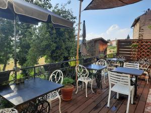 eine Terrasse mit Tischen und Stühlen auf einem Deck in der Unterkunft La Modestine in Le Monastier sur Gazeille