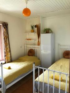 ein Schlafzimmer mit zwei Betten und einem Kühlschrank in der Unterkunft La Modestine in Le Monastier sur Gazeille