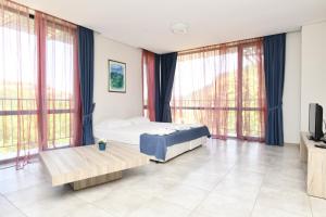 a bedroom with a bed and large windows at Complex Perpera in Stambolovo