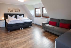 a bedroom with a bed and a couch at Alt Westerland Hüs in Westerland (Sylt)