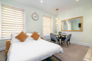 Un dormitorio con una cama y una mesa con sillas. en Cosy flat 5 min from Holland Park station! London, en Londres