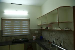 a kitchen with a sink and a window at Lush Green-Homestay in Pooppara +19 photos