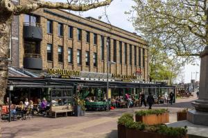 a large building with people sitting outside of it at Manzo's Suites in Zaandam