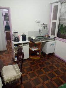 a kitchen with a counter and a table and a chair at Lolita House in Rio de Janeiro +3 photos