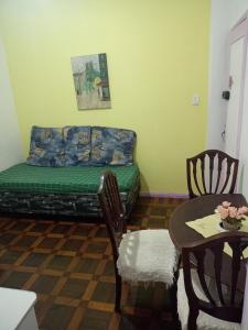 a living room with a bed and a table and chairs at Lolita House in Rio de Janeiro