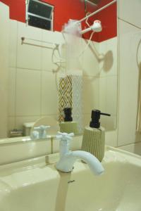 a bathroom sink with a faucet and a mirror at Casa na Estrada Real - Tiradentes in Tiradentes +22 photos
