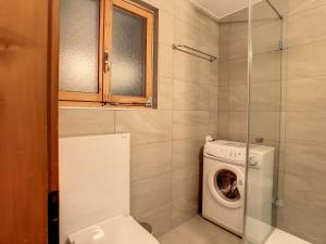 a bathroom with a toilet and a washing machine at Pâquerette 1er in Verbier