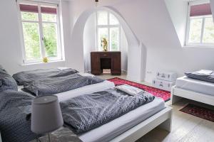 two beds in a white room with two windows at Schloss Suggenstein in Sigmaringen
