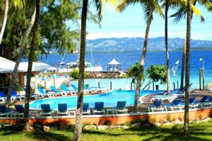 a swimming pool with lounge chairs and the water at Marina-Carayou 2 in Les Trois-Îlets