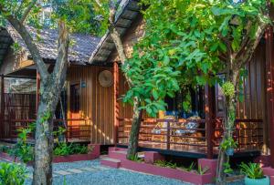 a building with trees in front of it at Habana Angkor Boutique Hotel in Siem Reap